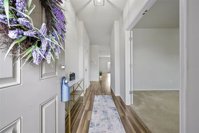 a view of a hallway with wooden floor and stairs