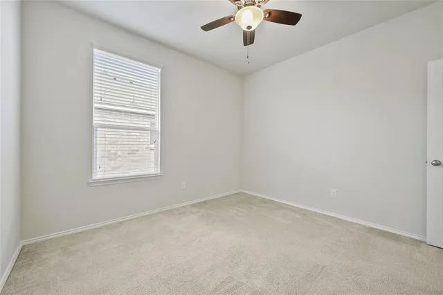 en empty room with windows and chandelier fan