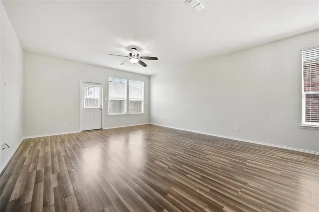 wooden floor in an empty room with a window