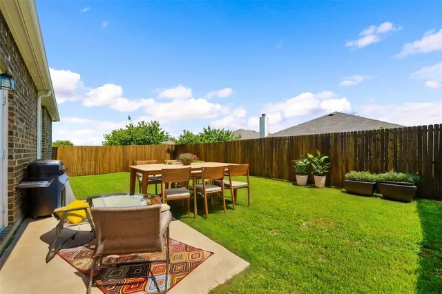 a view of backyard with seating area and green space