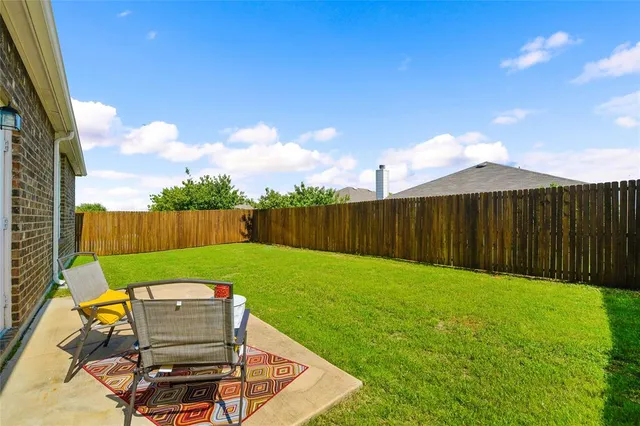 a view of a backyard with wooden fence