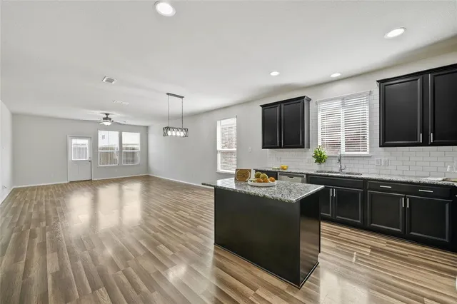 a kitchen with granite countertop a stove top oven sink and cabinets