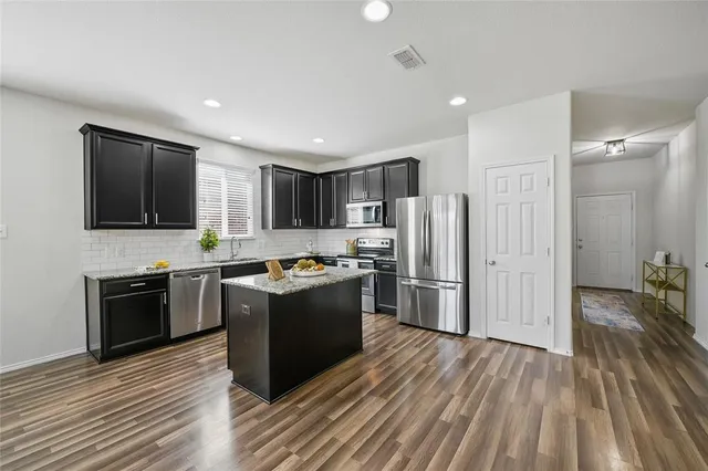 a kitchen with stainless steel appliances granite countertop a refrigerator stove and oven