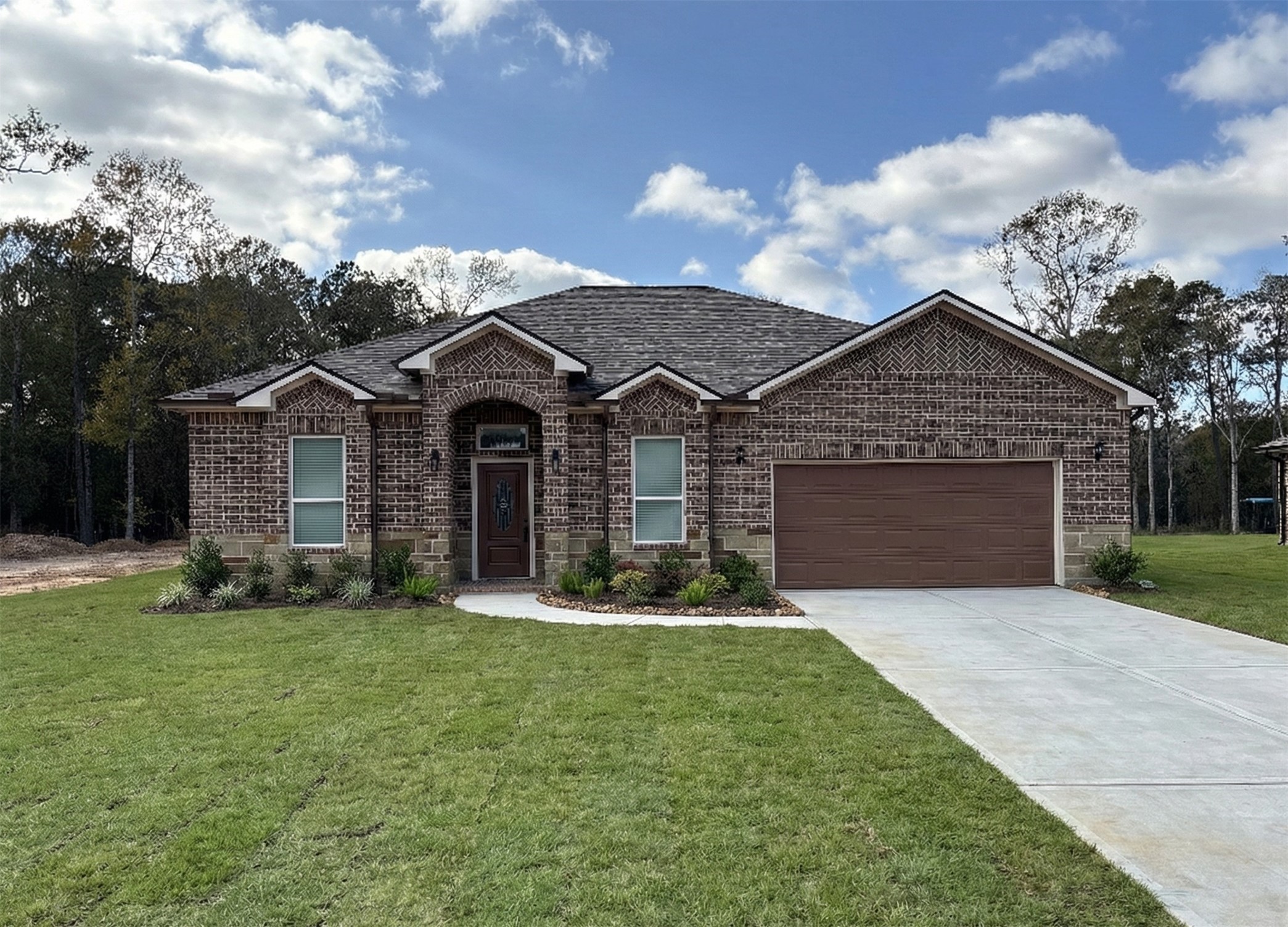 107 County Road 3372 Cleveland, TX 77327 - Photo 1 of 27 a front view of a house with a yard and garage