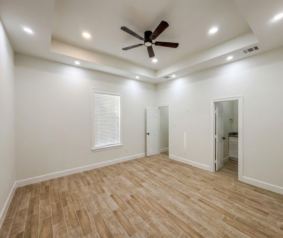 107 County Road 3372 Cleveland, TX 77327 - Photo 14 of 27 a view of an empty room and a ceiling fan & kitchen view