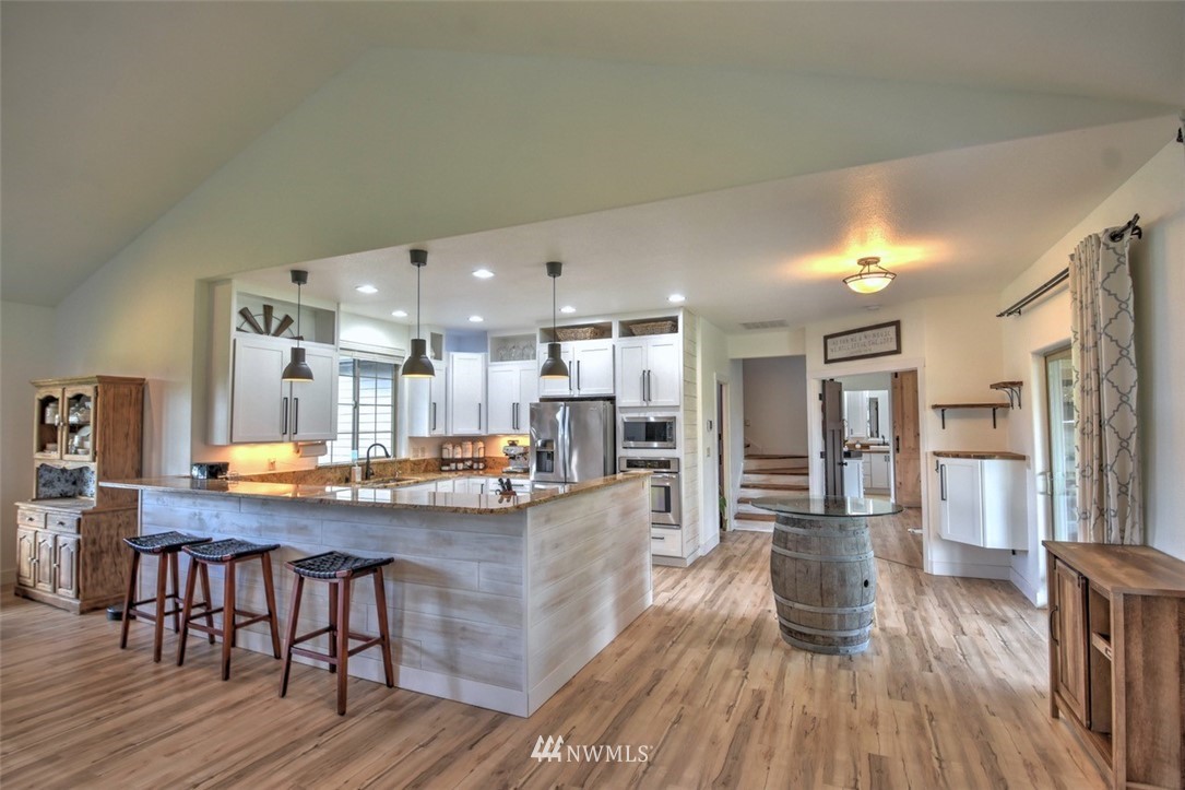 8637 183rd Avenue Southwest Rochester, WA 98579 - Photo 2 of 33 a kitchen with stainless steel appliances granite countertop a table chairs and a wooden floors