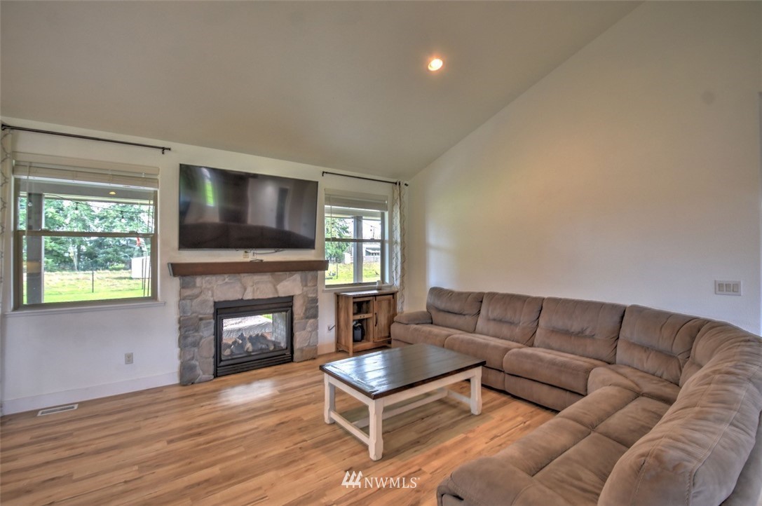 8637 183rd Avenue Southwest Rochester, WA 98579 - Photo 11 of 33 a living room with furniture flat screen tv and a fireplace