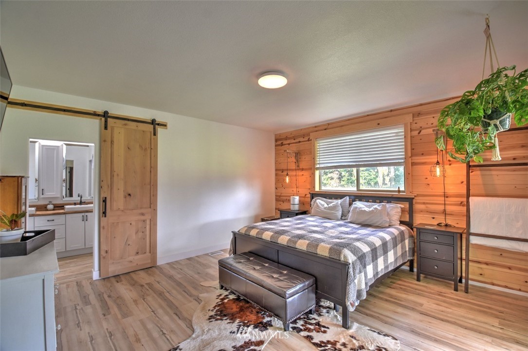 8637 183rd Avenue Southwest Rochester, WA 98579 - Photo 14 of 33 a bedroom with a bed and wooden floor