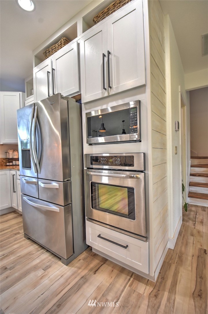 8637 183rd Avenue Southwest Rochester, WA 98579 - Photo 7 of 33 a kitchen with granite countertop a refrigerator stove and microwave