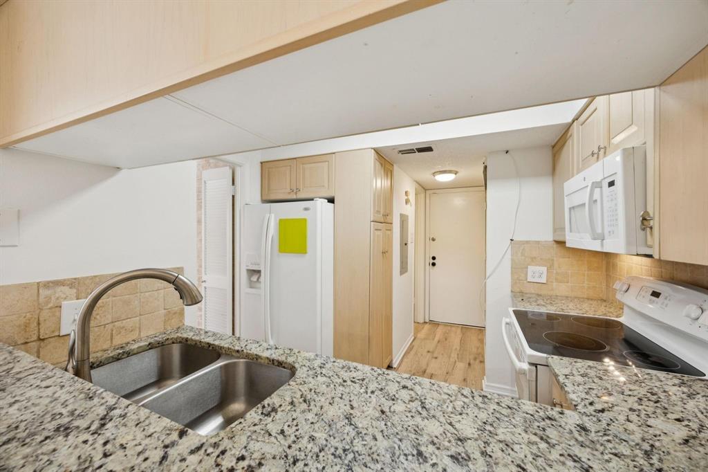 18240 Midway Road, Unit 904 Dallas, TX 75287 - Photo 11 of 26 a kitchen with a sink and a refrigerator