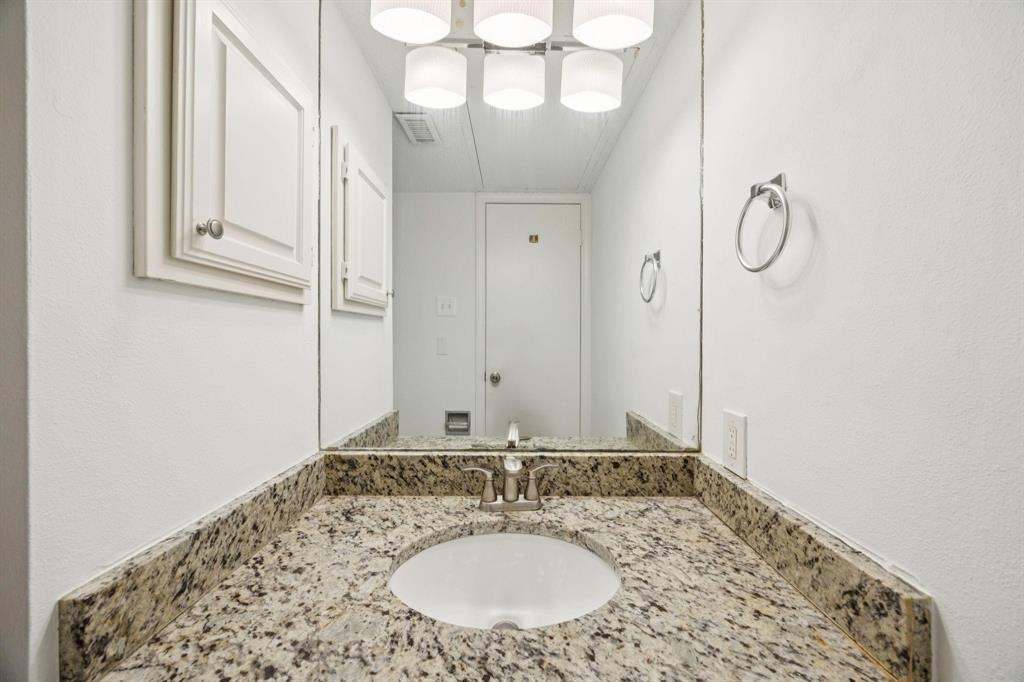 18240 Midway Road, Unit 904 Dallas, TX 75287 - Photo 13 of 26 a bathroom with a granite countertop sink and a mirror