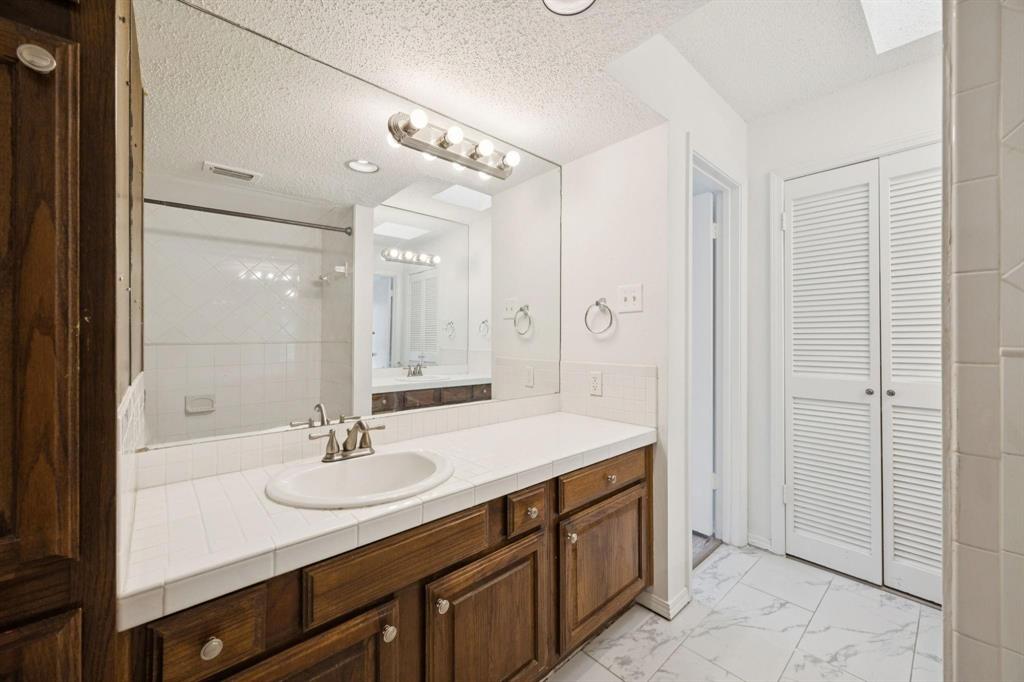 18240 Midway Road, Unit 904 Dallas, TX 75287 - Photo 19 of 26 a bathroom with a sink double vanity granite and a mirror