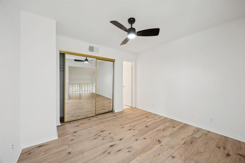 18240 Midway Road, Unit 904 Dallas, TX 75287 - Photo 20 of 26 an empty room with wooden floor cabinet and windows
