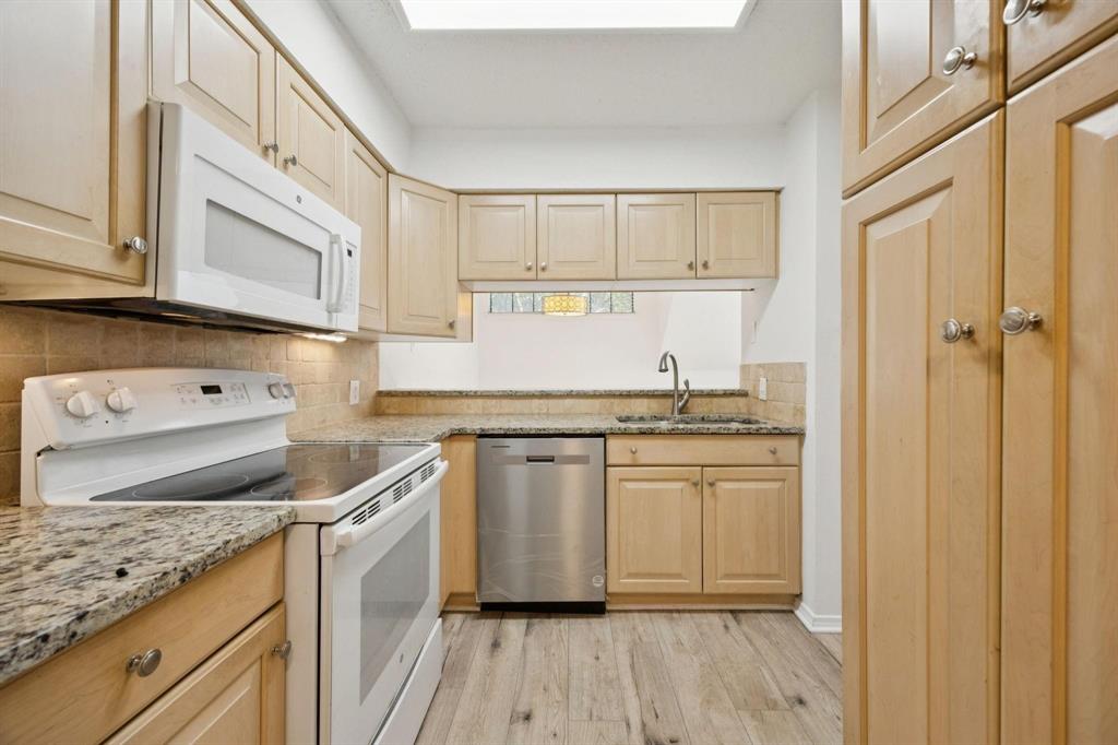 18240 Midway Road, Unit 904 Dallas, TX 75287 - Photo 10 of 26 a kitchen with stainless steel appliances granite countertop a sink stove and cabinets