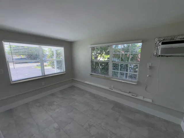 a view of a room that has wooden floor and a window