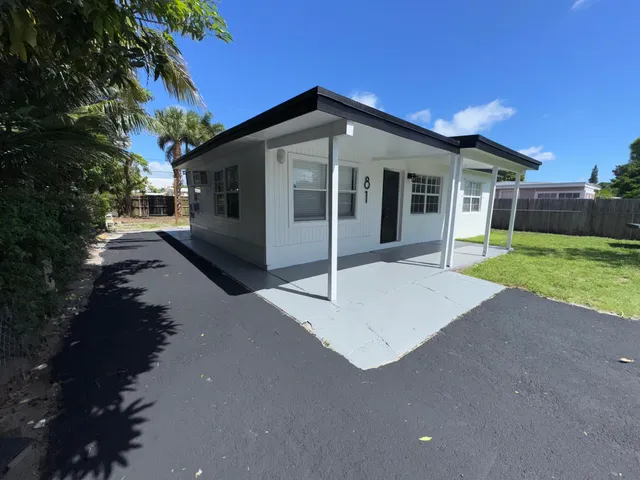 a view of house with backyard and glass windows