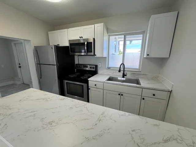 a kitchen with a sink appliances and cabinets