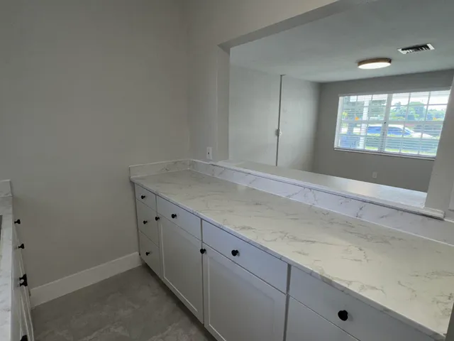 a kitchen with white cabinets and a sink