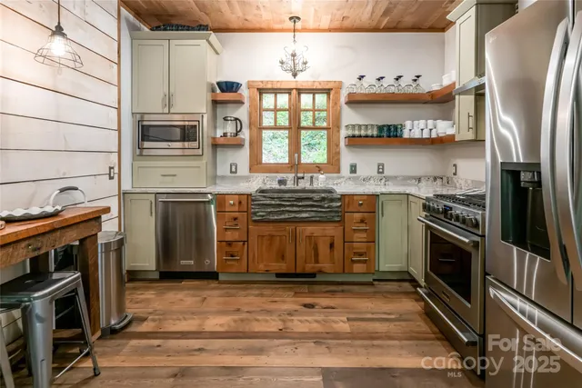 a kitchen with stainless steel appliances a stove a sink and a refrigerator