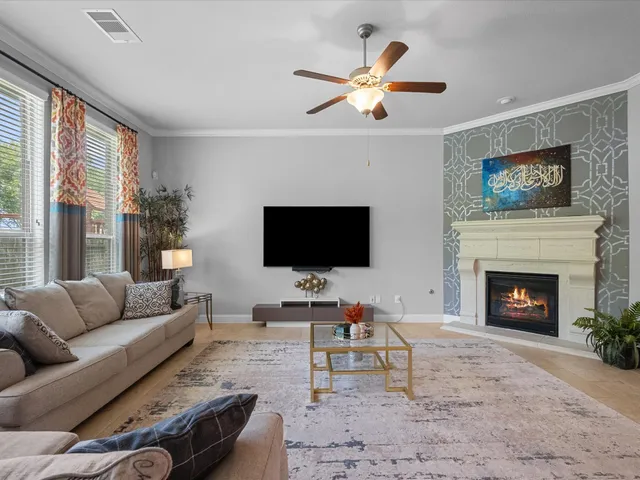 a living room with furniture a flat screen tv and a fireplace