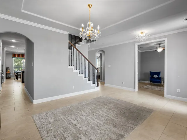 a view of a livingroom with a chandelier fan and windows