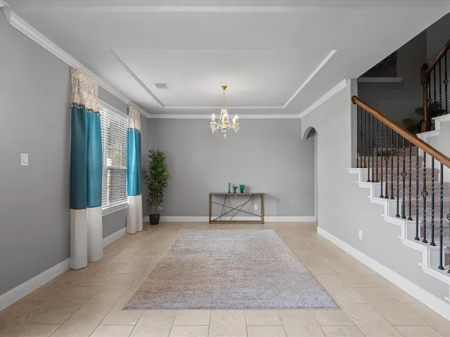 a view of an empty room with stairs and a floor to ceiling window