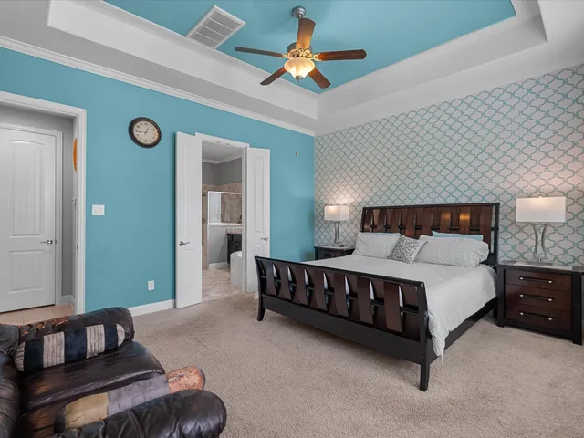 a spacious bedroom with a bed and a chandelier