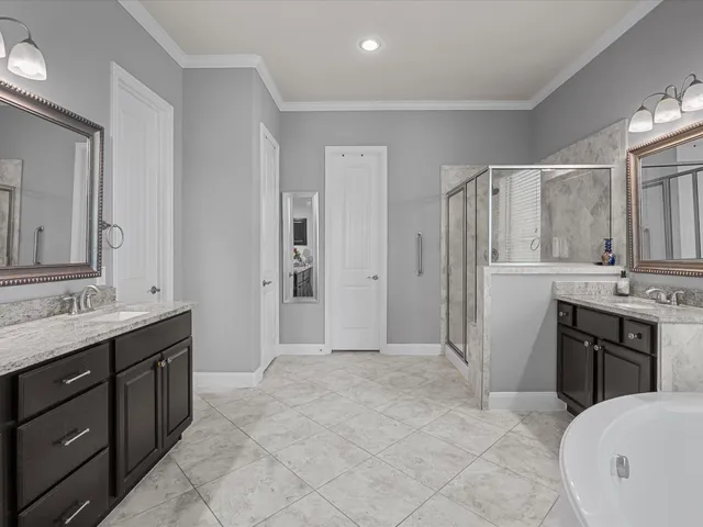 a spacious bathroom with a shower sink and mirror