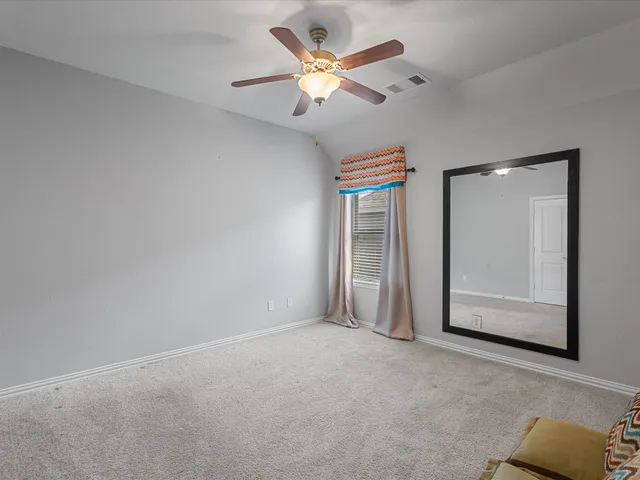 an empty room with closet and fan