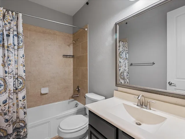 a bathroom with a sink a toilet a mirror a shower and a bathtub