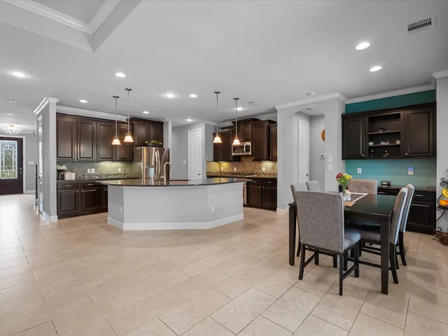 a view of kitchen with kitchen island stainless steel appliances refrigerator stove microwave and cabinets