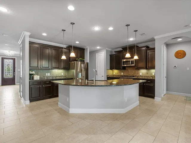 a large kitchen with kitchen island a sink stainless steel appliances and cabinets