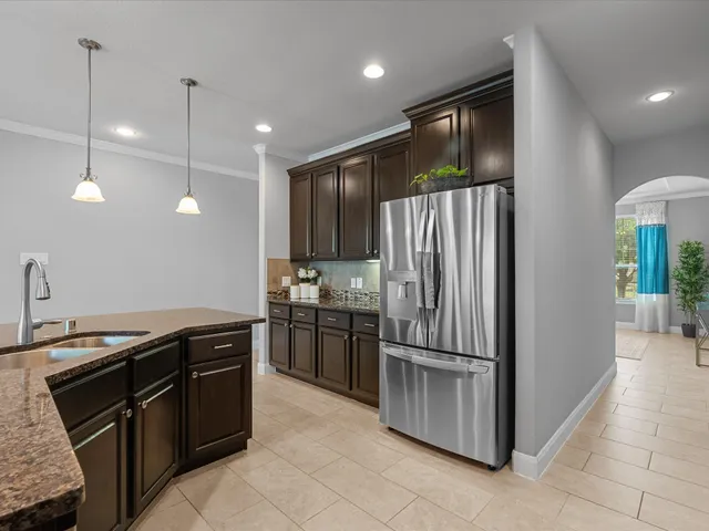 a kitchen with stainless steel appliances granite countertop a refrigerator a stove and a sink