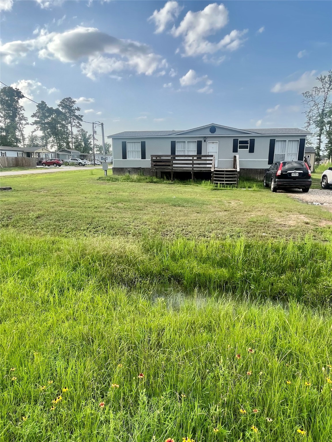 a view of a large pool with lawn chairs and a big yard