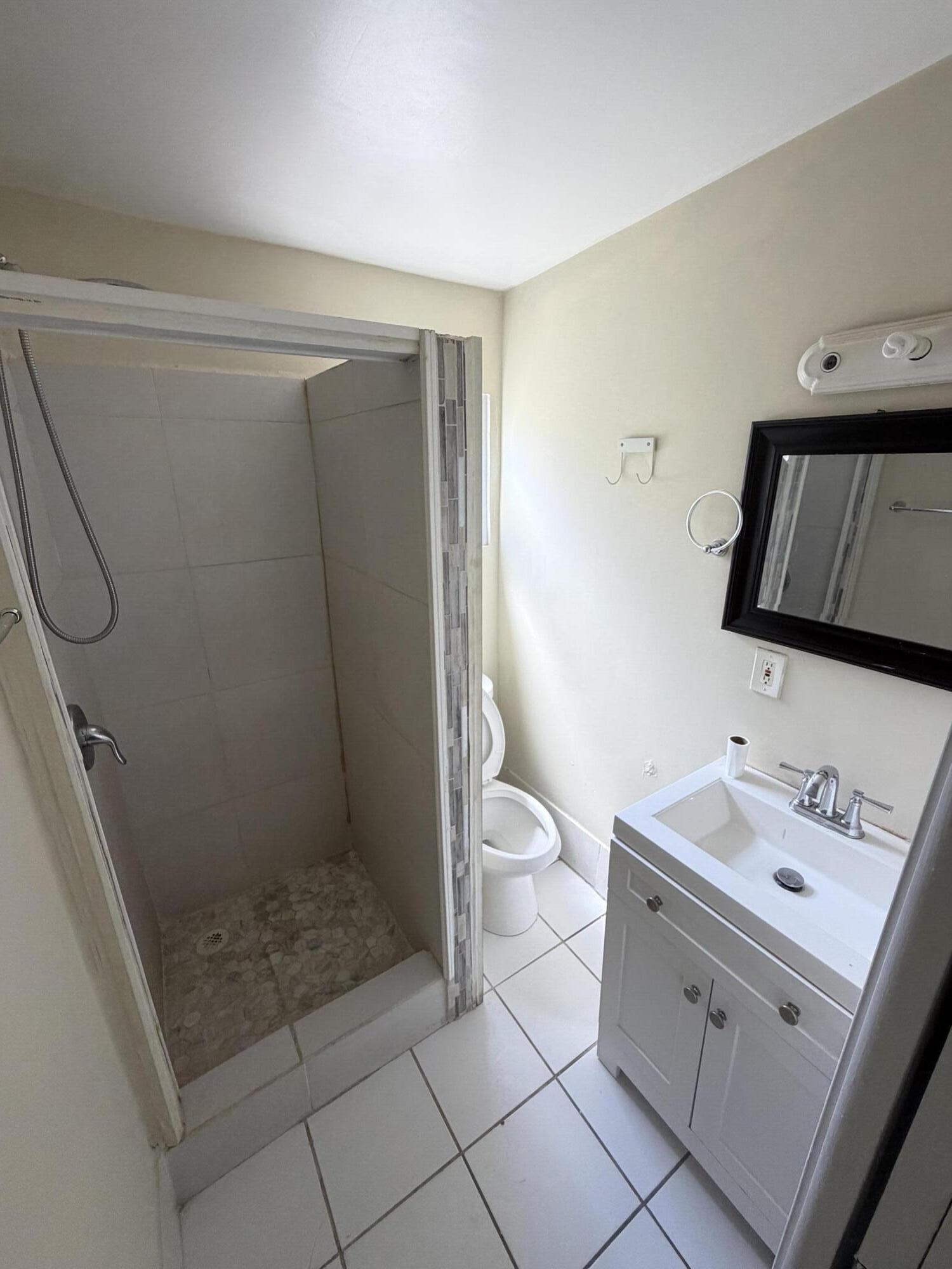 520 Seagrape Road Lantana, FL 33462 - Photo 15 of 16 a bathroom with a sink a toilet and shower