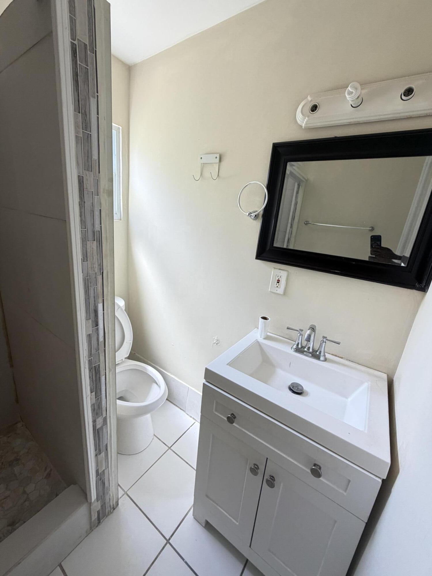 520 Seagrape Road Lantana, FL 33462 - Photo 16 of 16 a bathroom with a sink a toilet and mirror