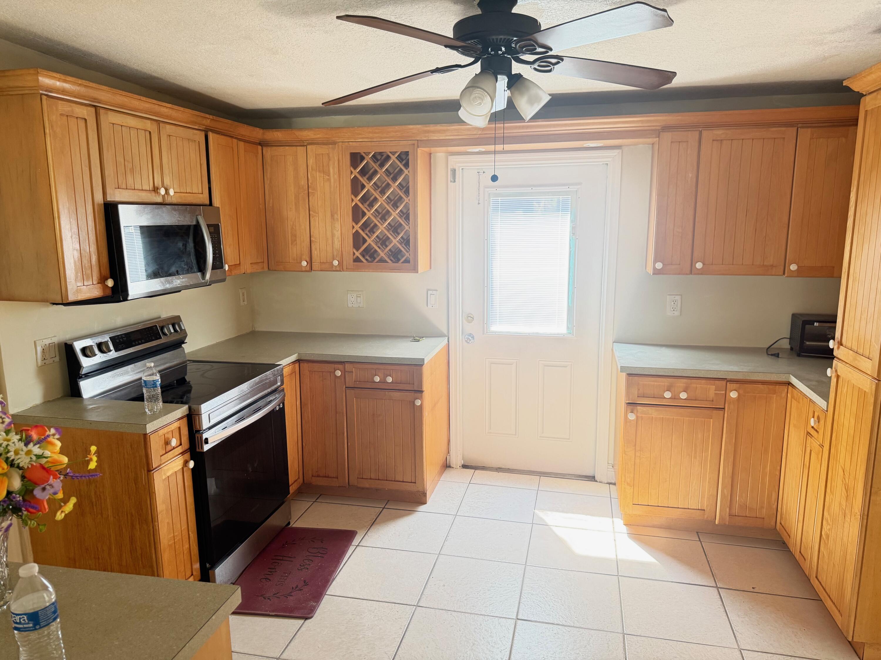 520 Seagrape Road Lantana, FL 33462 - Photo 4 of 16 a kitchen with a stove a microwave and a sink