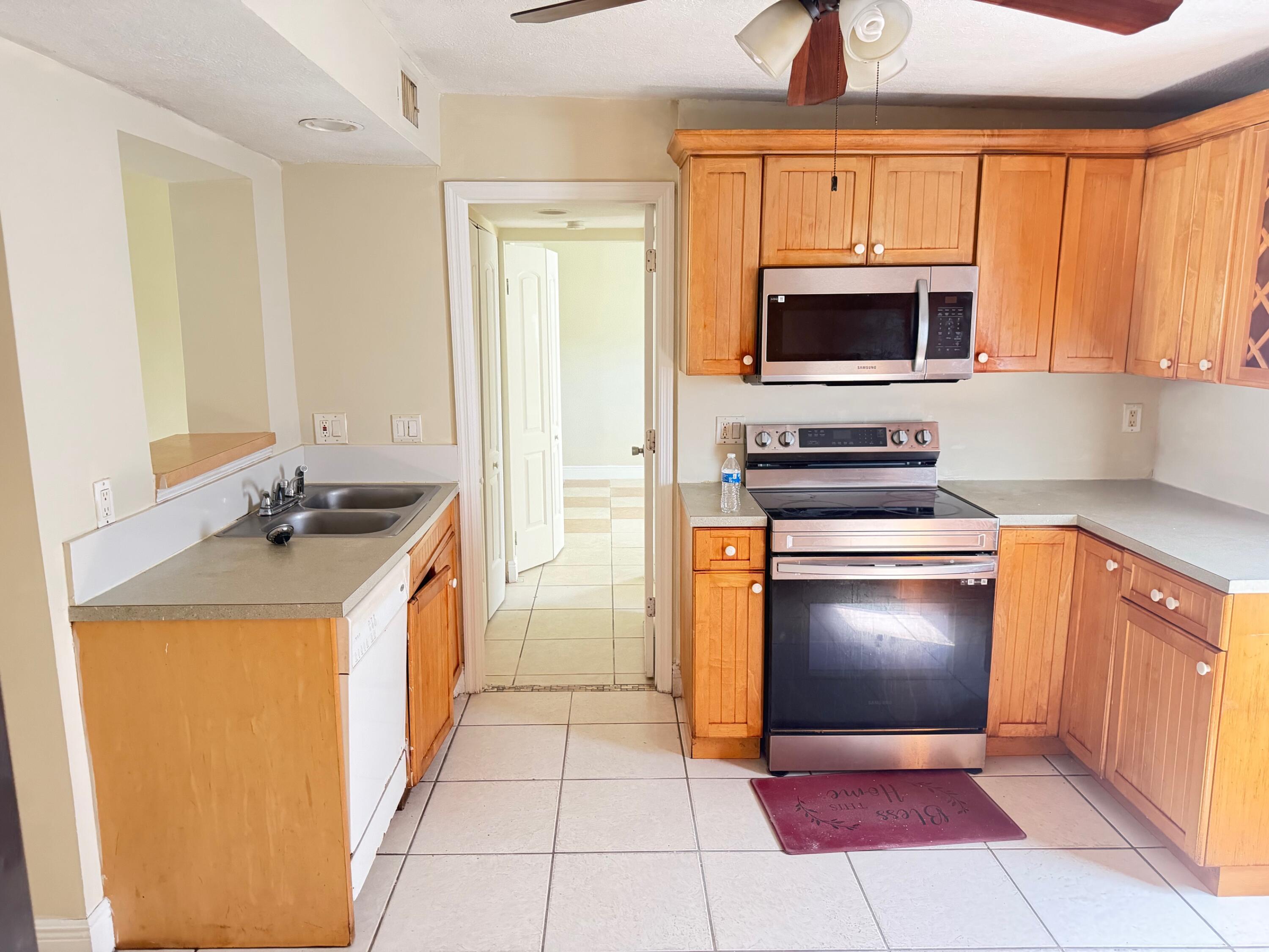 520 Seagrape Road Lantana, FL 33462 - Photo 7 of 16 a kitchen with stainless steel appliances granite countertop a stove a sink and a microwave