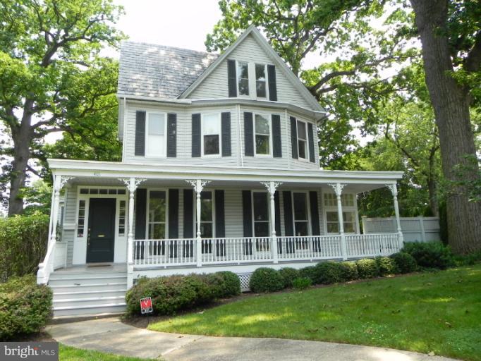 401 Hawthorn Road Baltimore, MD 21210 - Photo 1 of 26 a view of a white house with a large window and a yard with plants and large trees