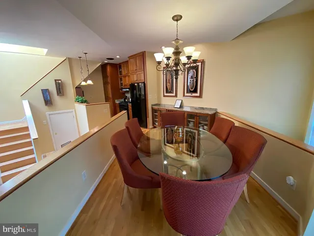 a dining room with furniture a chandelier and wooden floor