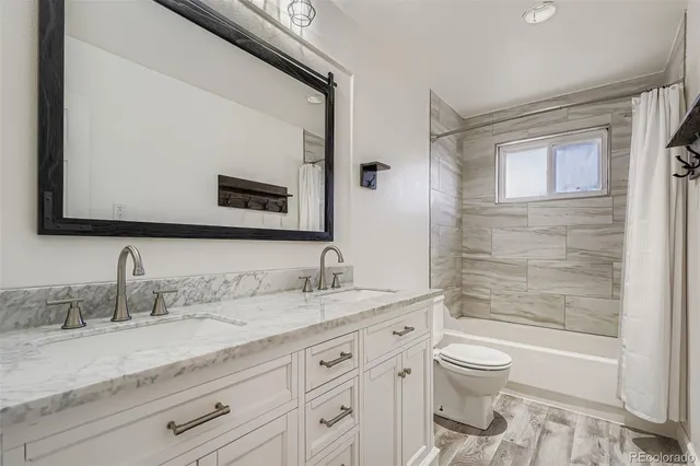 a bathroom with a granite countertop sink a toilet and a bathtub