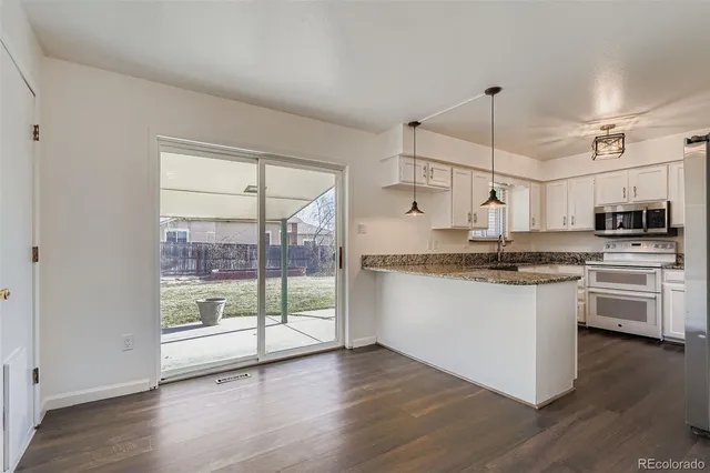 a kitchen with stainless steel appliances granite countertop a stove a sink and a refrigerator