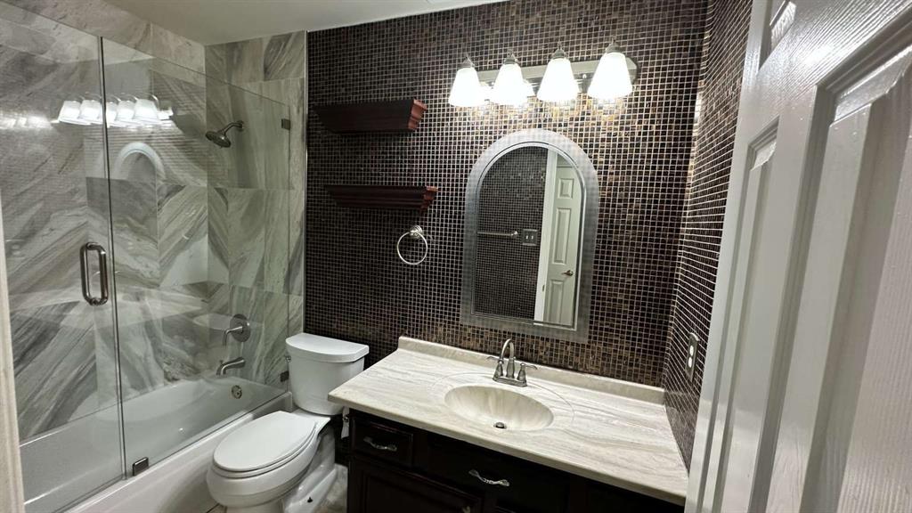 5713 Allen Lane Rowlett, TX 75088 - Photo 19 of 20 a bathroom with a sink a toilet a mirror and shower