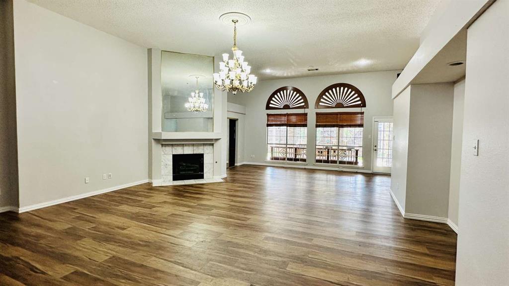 5713 Allen Lane Rowlett, TX 75088 - Photo 3 of 20 a view of a room with wooden floor fireplace and windows