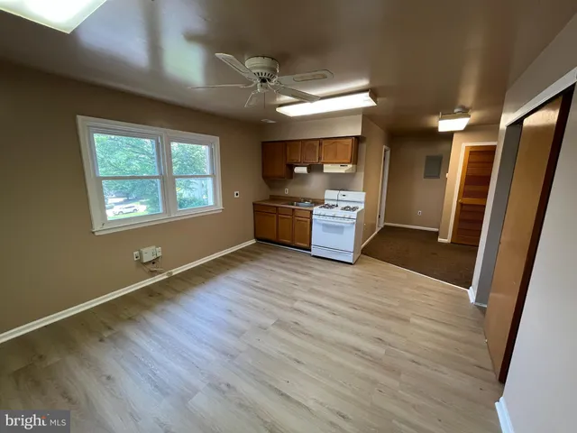 a large space with wooden floor and a window