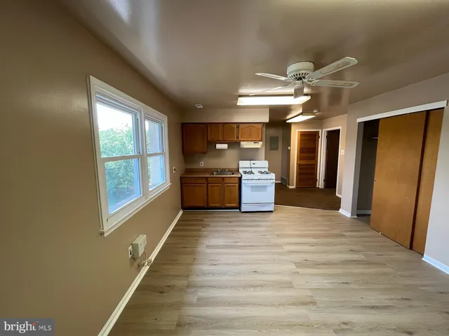 a view of a hallway with wooden floor and chandelier