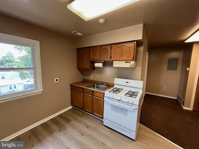a kitchen with wooden floors and appliances