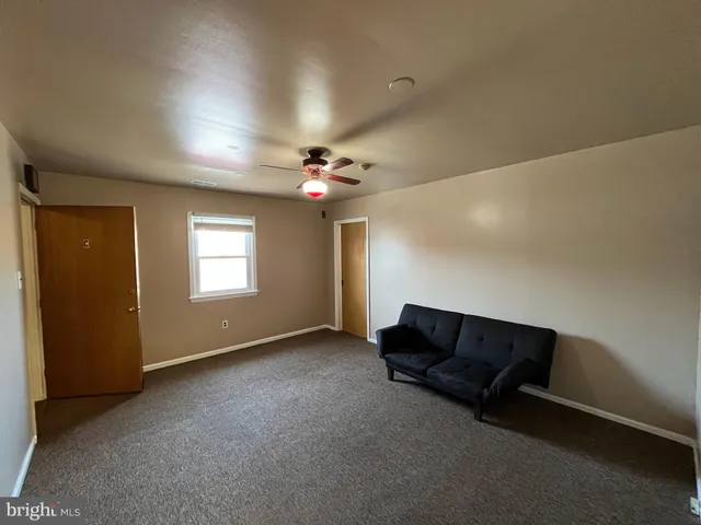 an empty room with windows and ceiling fan
