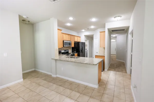 a view of kitchen with granite countertop cabinets and window