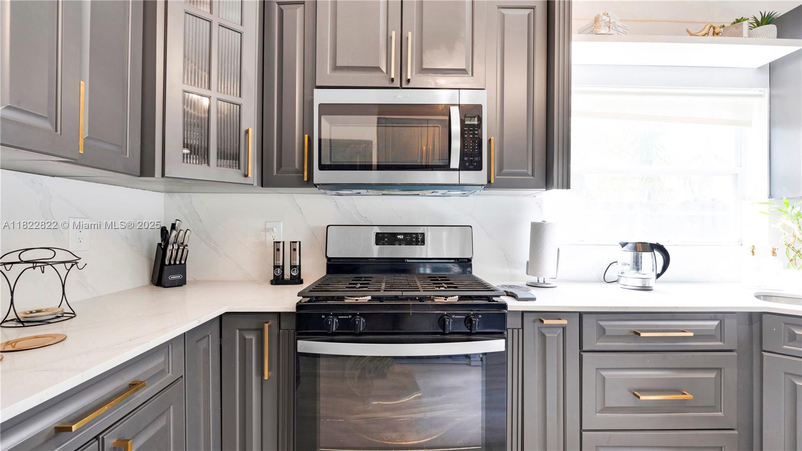 8356 Southwest 158th Avenue Miami, FL 33193 - Photo 15 of 48 a kitchen with stainless steel appliances granite countertop a sink stove and microwave